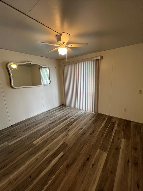 13891 Southeast 126th Boulevard, Unit 121 Okeechobee, FL 34974 - Photo 18 of 45 a view of a livingroom with a ceiling fan and wooden floor