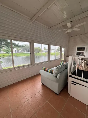 a living room with furniture and a floor to ceiling window