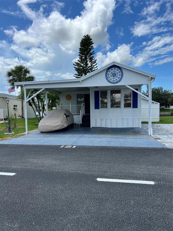 13891 Southeast 126th Boulevard, Unit 121 Okeechobee, FL 34974 - Photo 3 of 45 a front view of a house with a yard