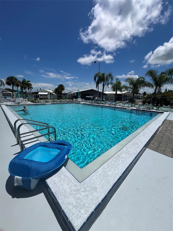 13891 Southeast 126th Boulevard, Unit 121 Okeechobee, FL 34974 - Photo 36 of 45 a view of a swimming pool with a table and chairs