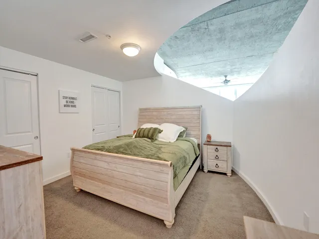 a bed sitting in a bedroom next to a larger window