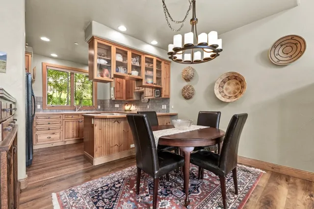 a dining room with wooden floor and a chandelier