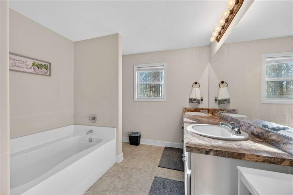336 Dixie Ct Mount Mount Airy, GA 30563 - Photo 21 of 41 a bathroom with a granite countertop sink and a bathtub