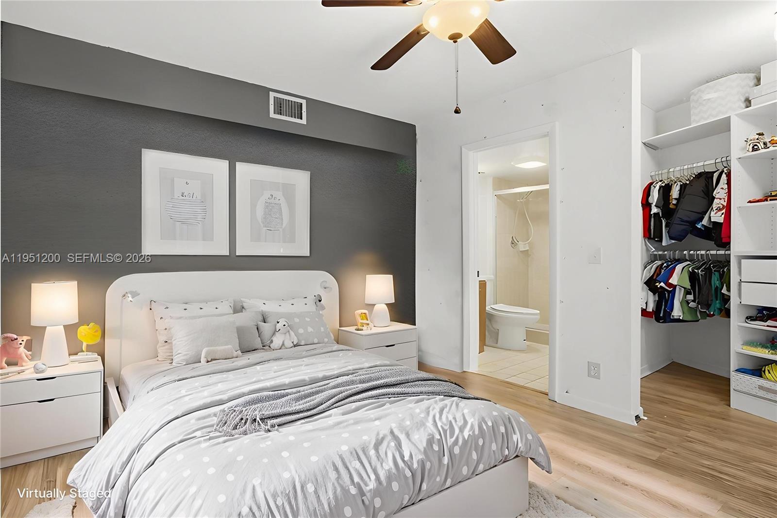 23024 Oxford Place, Unit C Boca Raton, FL 33433 - Photo 12 of 22 a bedroom with a large bed and a chandelier