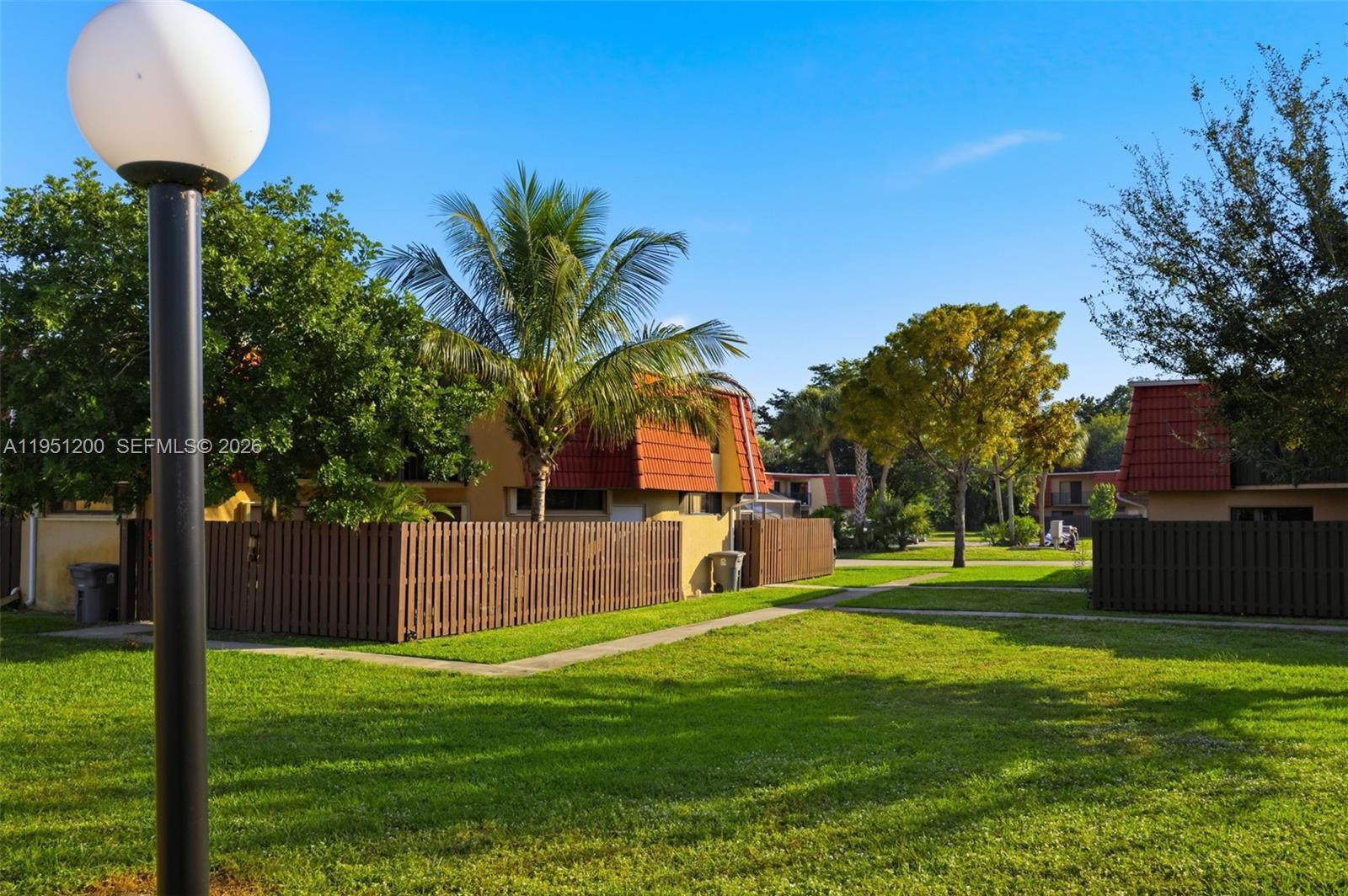 23024 Oxford Place, Unit C Boca Raton, FL 33433 - Photo 19 of 22 a front view of a house with garden and trees