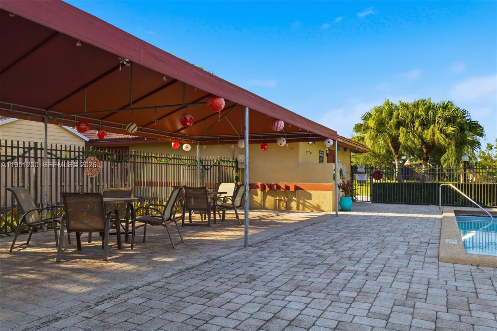 23024 Oxford Place, Unit C Boca Raton, FL 33433 - Photo 21 of 22 a view of a patio with a table and chairs under an umbrella
