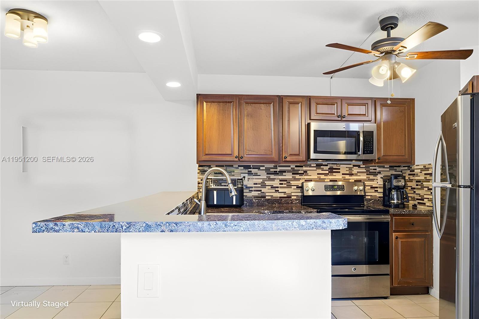 23024 Oxford Place, Unit C Boca Raton, FL 33433 - Photo 5 of 22 a kitchen with a stove and a microwave