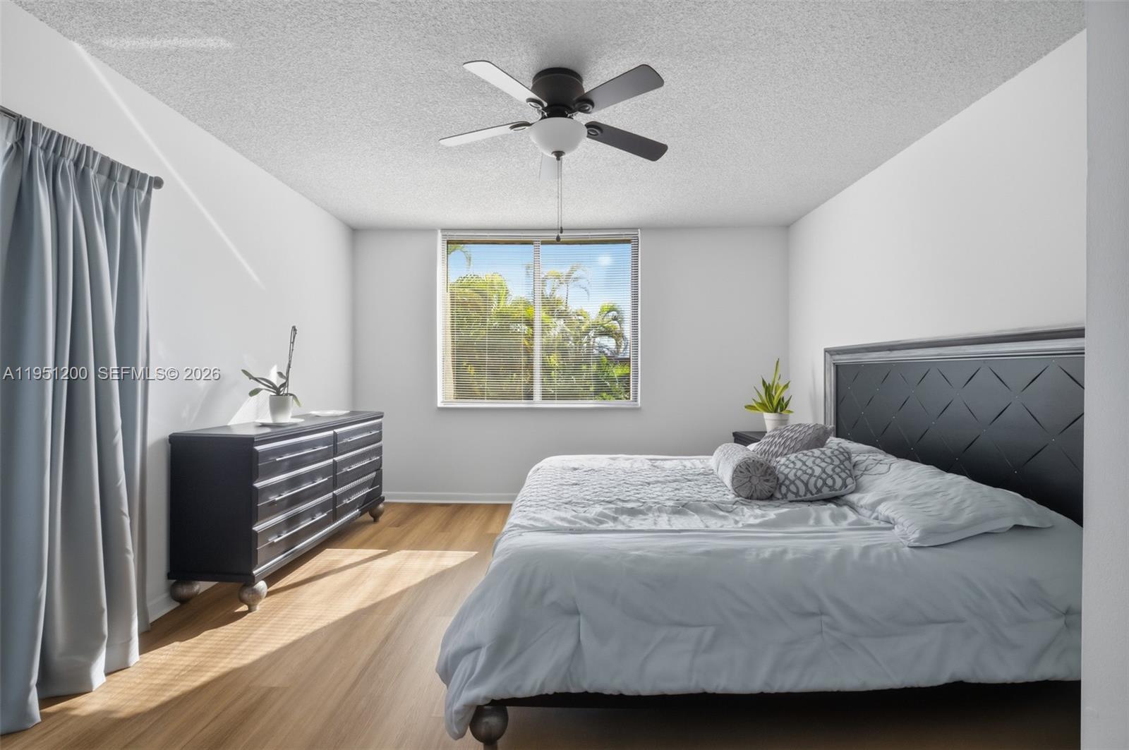 23024 Oxford Place, Unit C Boca Raton, FL 33433 - Photo 6 of 22 a bedroom with a bed and a chandelier