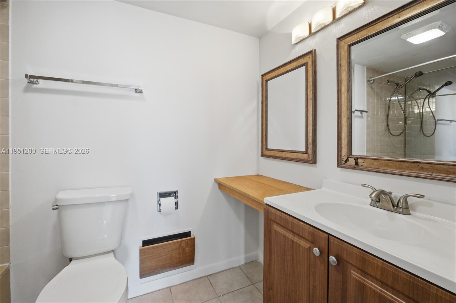 23024 Oxford Place, Unit C Boca Raton, FL 33433 - Photo 9 of 22 a bathroom with a sink a toilet and mirror