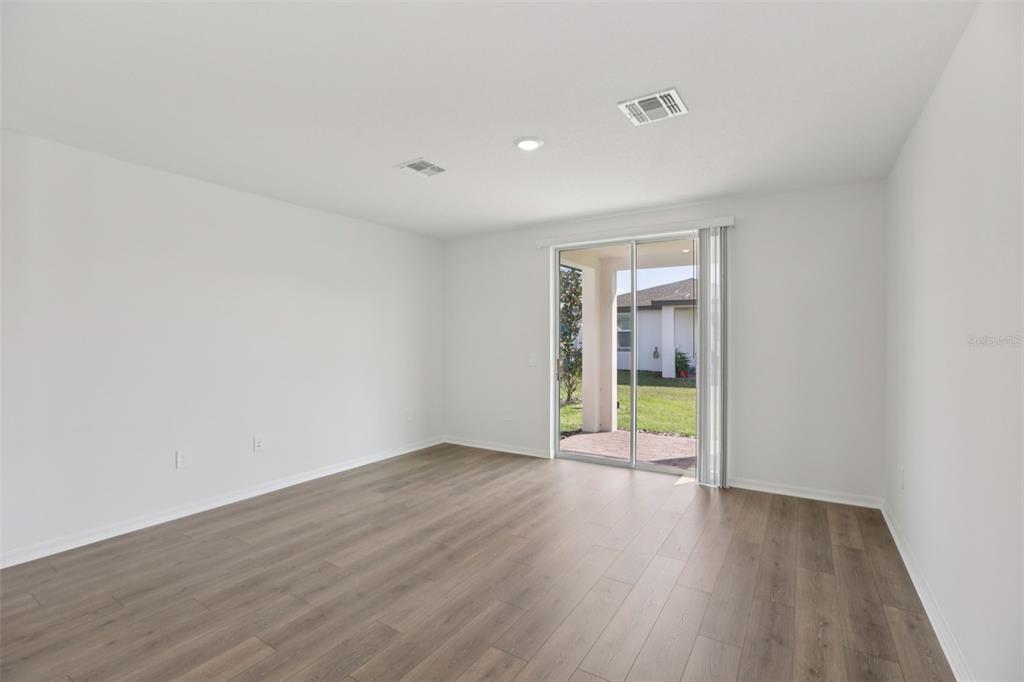 643 Pennywort Street Lake Alfred, FL 33850 - Photo 11 of 47 a view of an empty room with wooden floor and a window