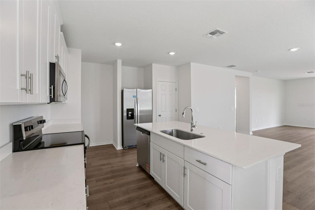 643 Pennywort Street Lake Alfred, FL 33850 - Photo 14 of 47 a kitchen with stainless steel appliances a sink stove and refrigerator