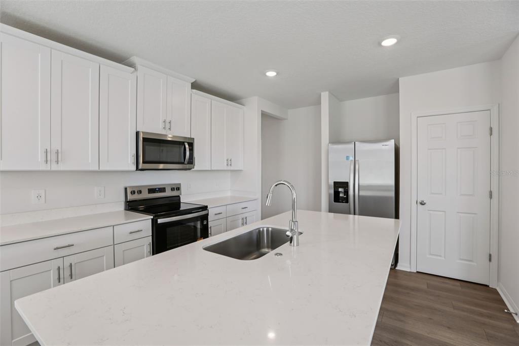 643 Pennywort Street Lake Alfred, FL 33850 - Photo 16 of 47 a kitchen with stainless steel appliances a microwave a sink a refrigerator and cabinets