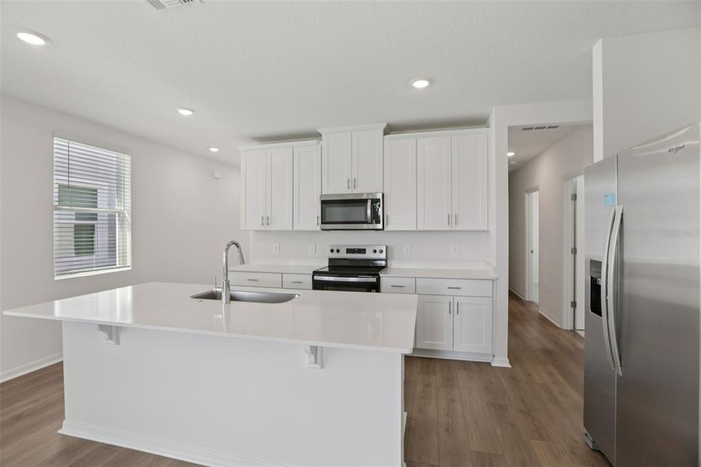 643 Pennywort Street Lake Alfred, FL 33850 - Photo 18 of 47 a kitchen with stainless steel appliances granite countertop a refrigerator a stove a sink and a microwave