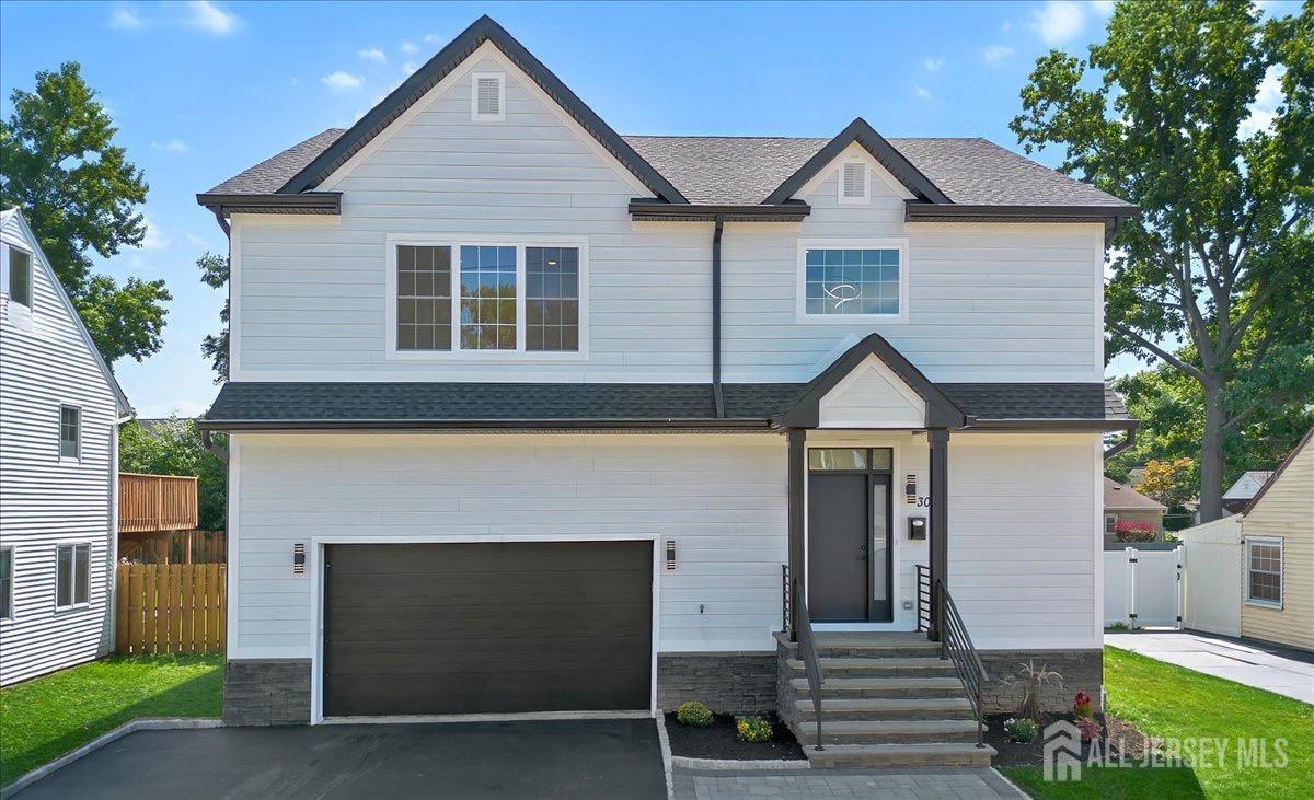 a front view of a house with a garden and garage