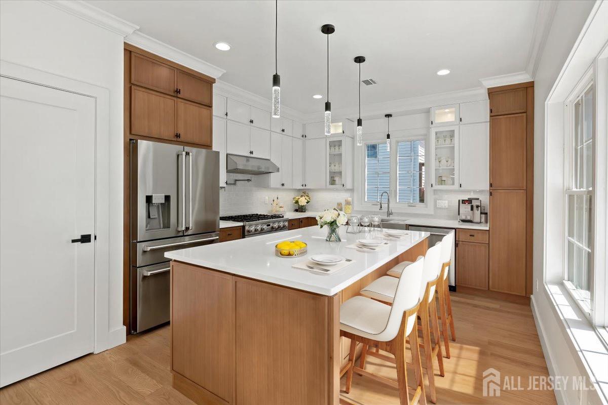 30 Ashley Road Edison, NJ 08817 - Photo 9 of 39 a kitchen with stainless steel appliances granite countertop a table chairs wooden floors and a refrigerator