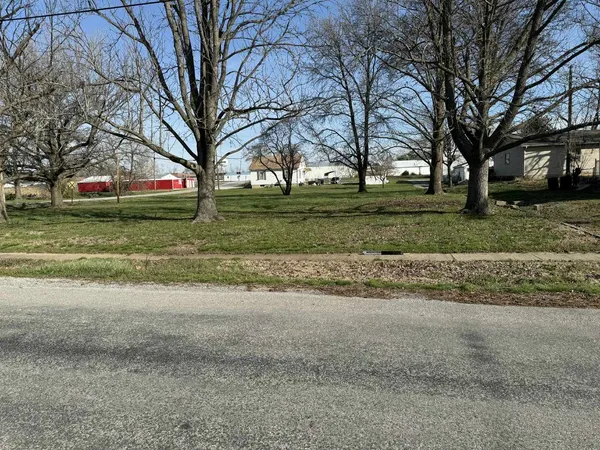 a view of a house with a big yard and large trees