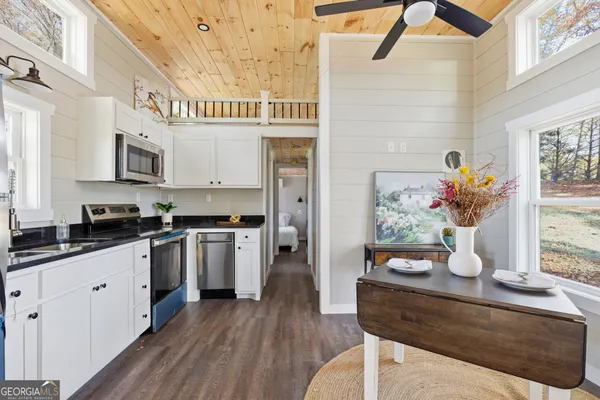 a kitchen with stainless steel appliances kitchen island granite countertop a table and a cabinets