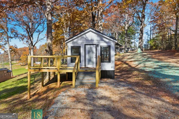 a view of a house with backyard and trees