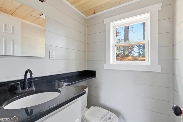 a bathroom with a sink toilet and a mirror