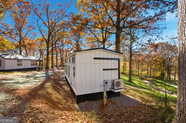 a view of backyard with a large tree and wooden fence