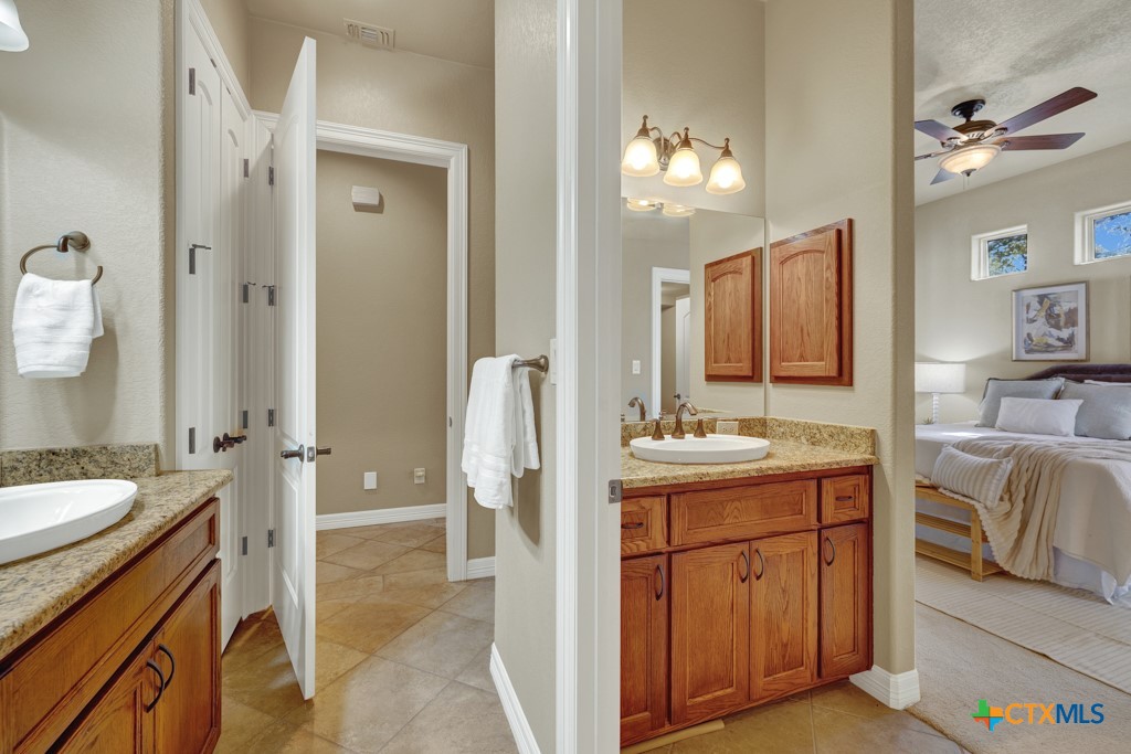 7607 Sky Loop Garden Ridge, TX 78266 - Photo 27 of 43 a en suite bathroom with a granite countertop sink and a mirror