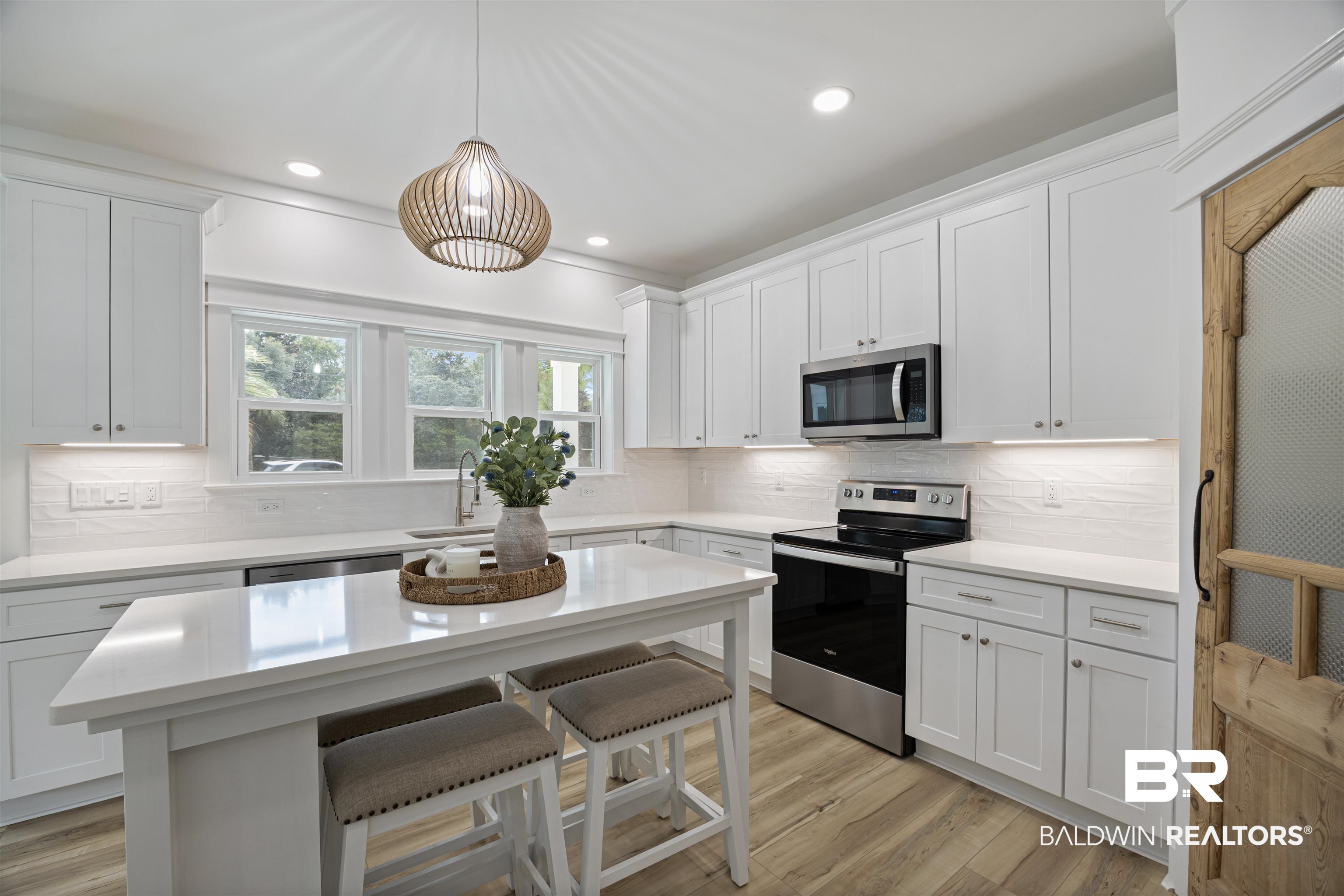 27591 Canal Road Orange Beach, AL 36561 - Photo 13 of 51 Kitchen with stainless steel appliances, tasteful backsplash, recessed lighting, white cabinetry, and a breakfast bar area