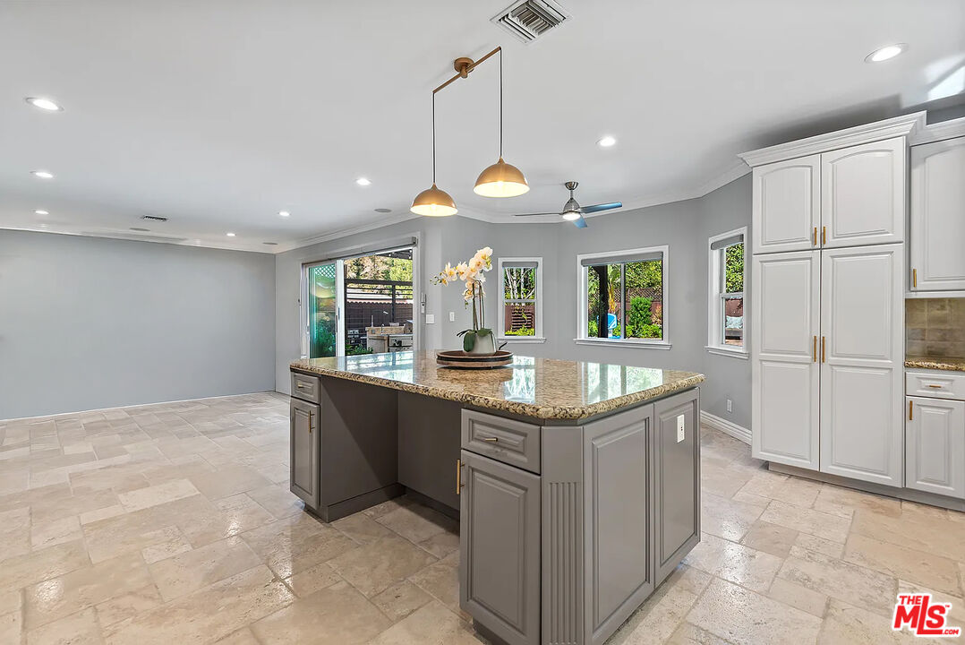 4724 Noble Avenue Sherman Oaks, CA 91403 - Photo 16 of 35 a kitchen with stainless steel appliances granite countertop a sink and a refrigerator