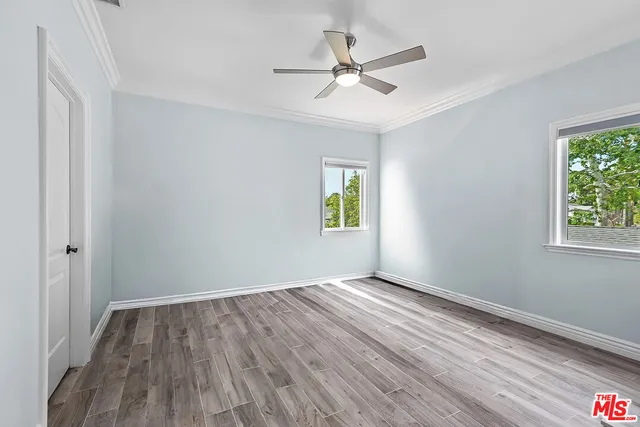 a view of empty room with wooden floor and fireplace