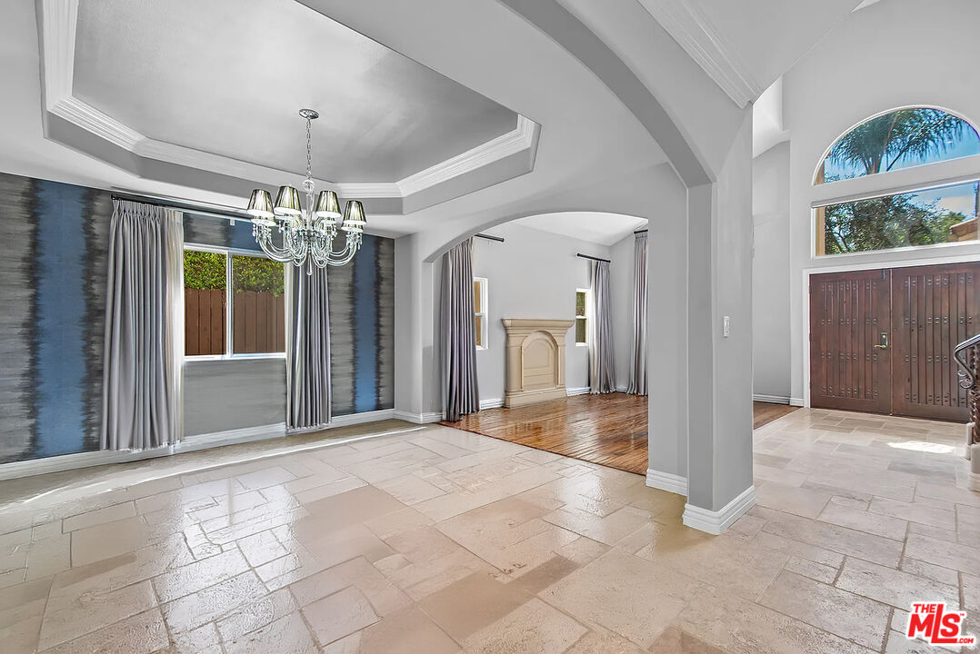 4724 Noble Avenue Sherman Oaks, CA 91403 - Photo 8 of 35 a view of a hallway with a chandelier and dining table