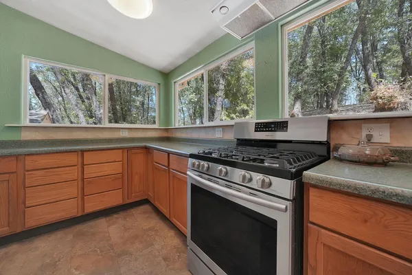 a kitchen with a stove a sink and a window