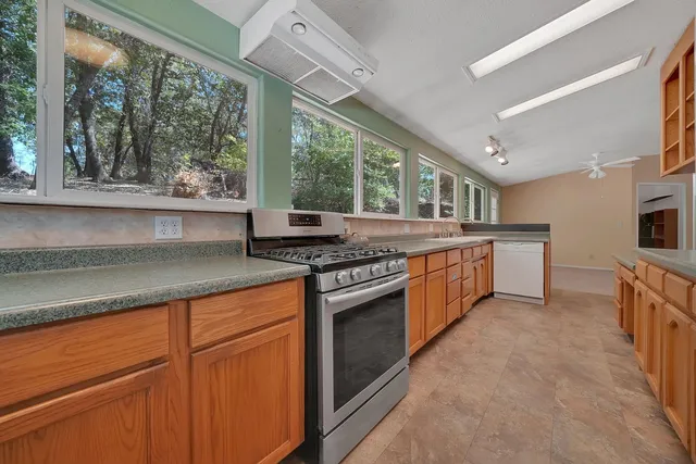 a kitchen with stainless steel appliances granite countertop a stove a sink and a refrigerator