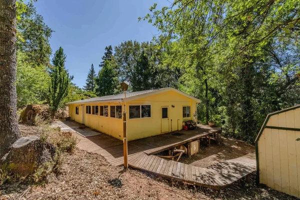 a view of a house with a yard patio and wooden deck