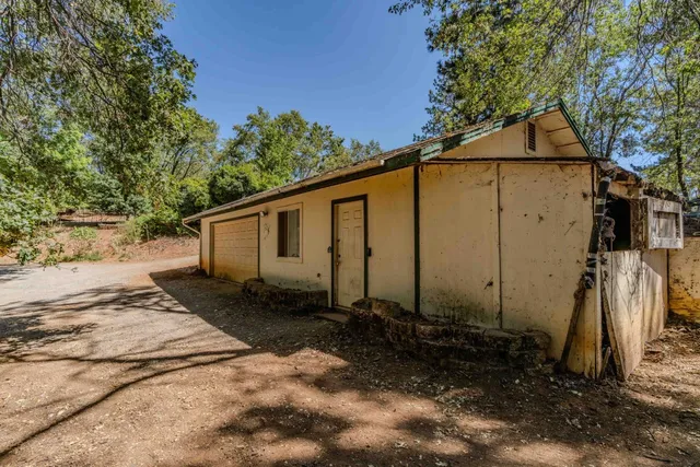 an aerial view of a wooden house next to a yard