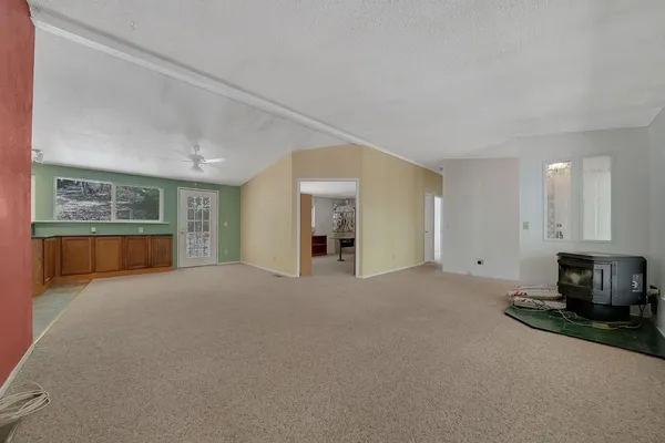 a view of an empty room with a fireplace and a window