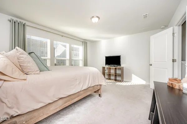 a bedroom with a bed and a large window