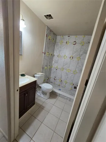 a spacious bathroom with a granite countertop sink toilet and shower