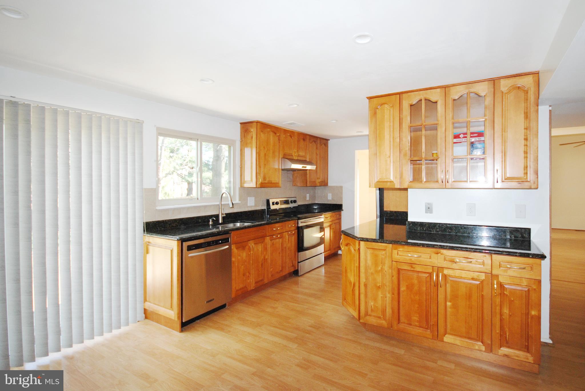 11609 Piney Lodge Road North Potomac, MD 20878 - Photo 13 of 25 a kitchen with stainless steel appliances granite countertop a stove a sink and a microwave
