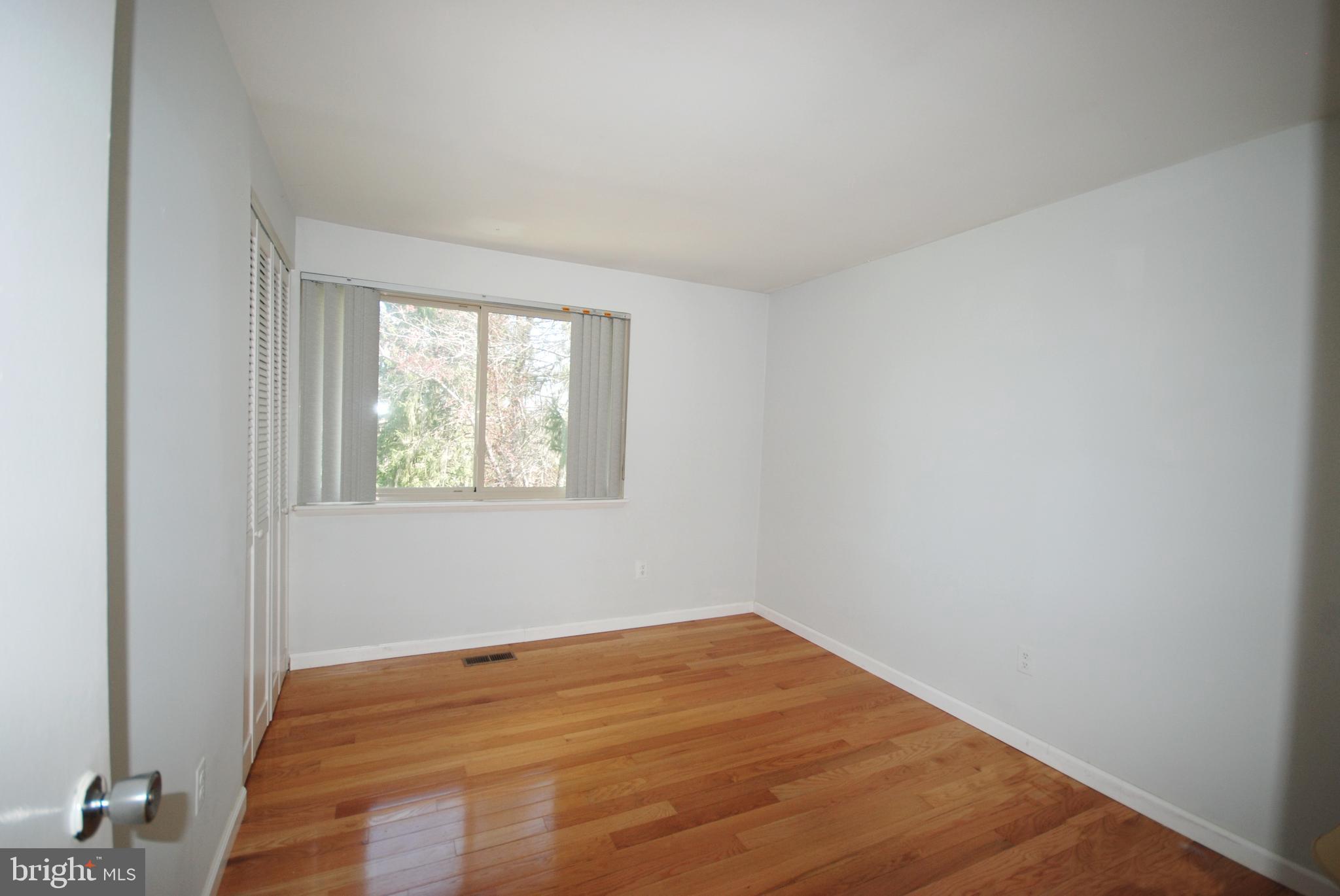 11609 Piney Lodge Road North Potomac, MD 20878 - Photo 16 of 25 a view of an empty room with wooden floor and a window