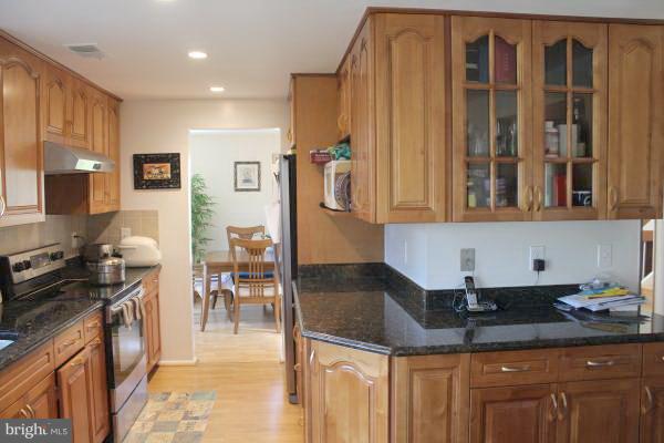 11609 Piney Lodge Road North Potomac, MD 20878 - Photo 6 of 25 a kitchen with stainless steel appliances granite countertop a stove and a sink
