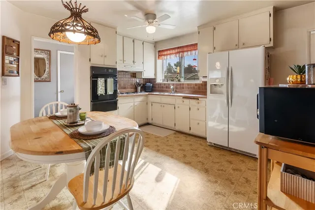 a kitchen with stainless steel appliances granite countertop a sink a stove a dining table and chairs