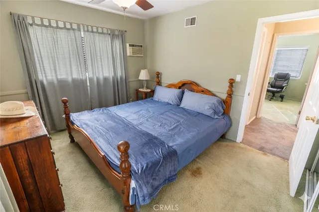 a bedroom with a bed and a mirror on dresser