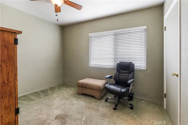 a view of a workspace with furniture and a window