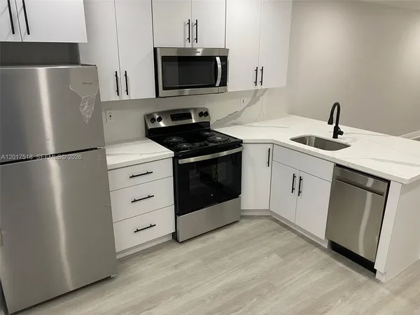 a kitchen with stainless steel appliances a refrigerator stove and microwave