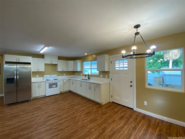 a kitchen with stainless steel appliances granite countertop a sink cabinets and wooden floor