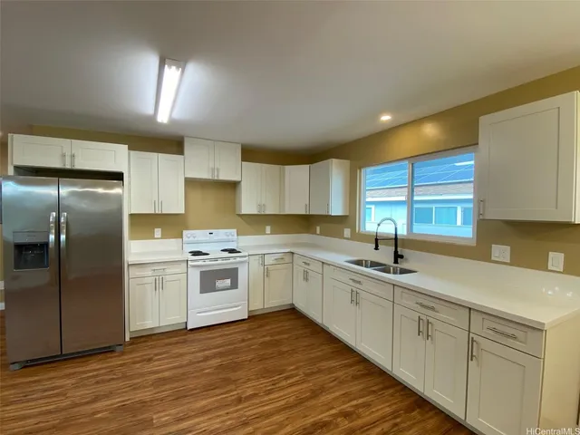 a kitchen with a sink cabinets stainless steel appliances and a window