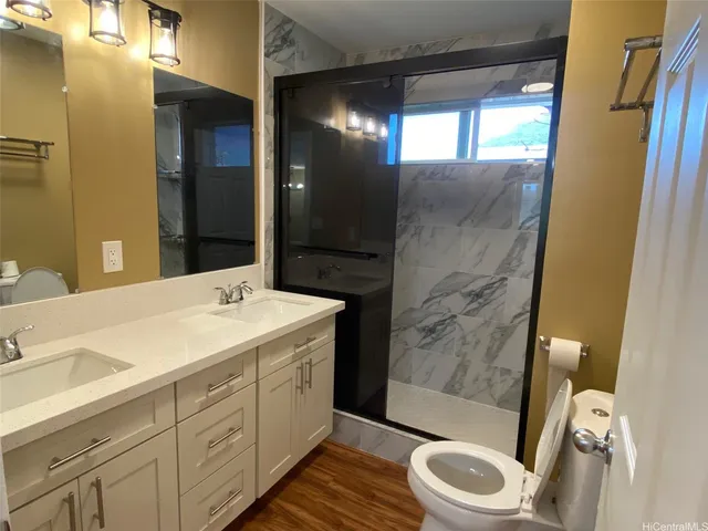 a bathroom with a sink a toilet and shower