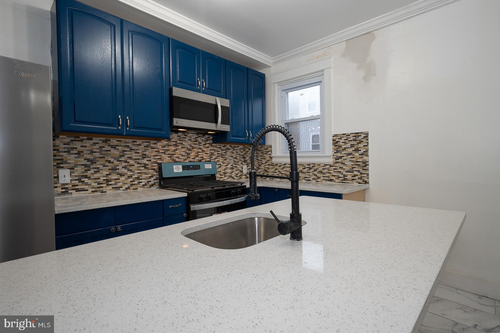 212 Copley Road Upper Darby, PA 19082 - Photo 17 of 69 a kitchen with granite countertop wooden cabinets a stove top oven a sink and dishwasher