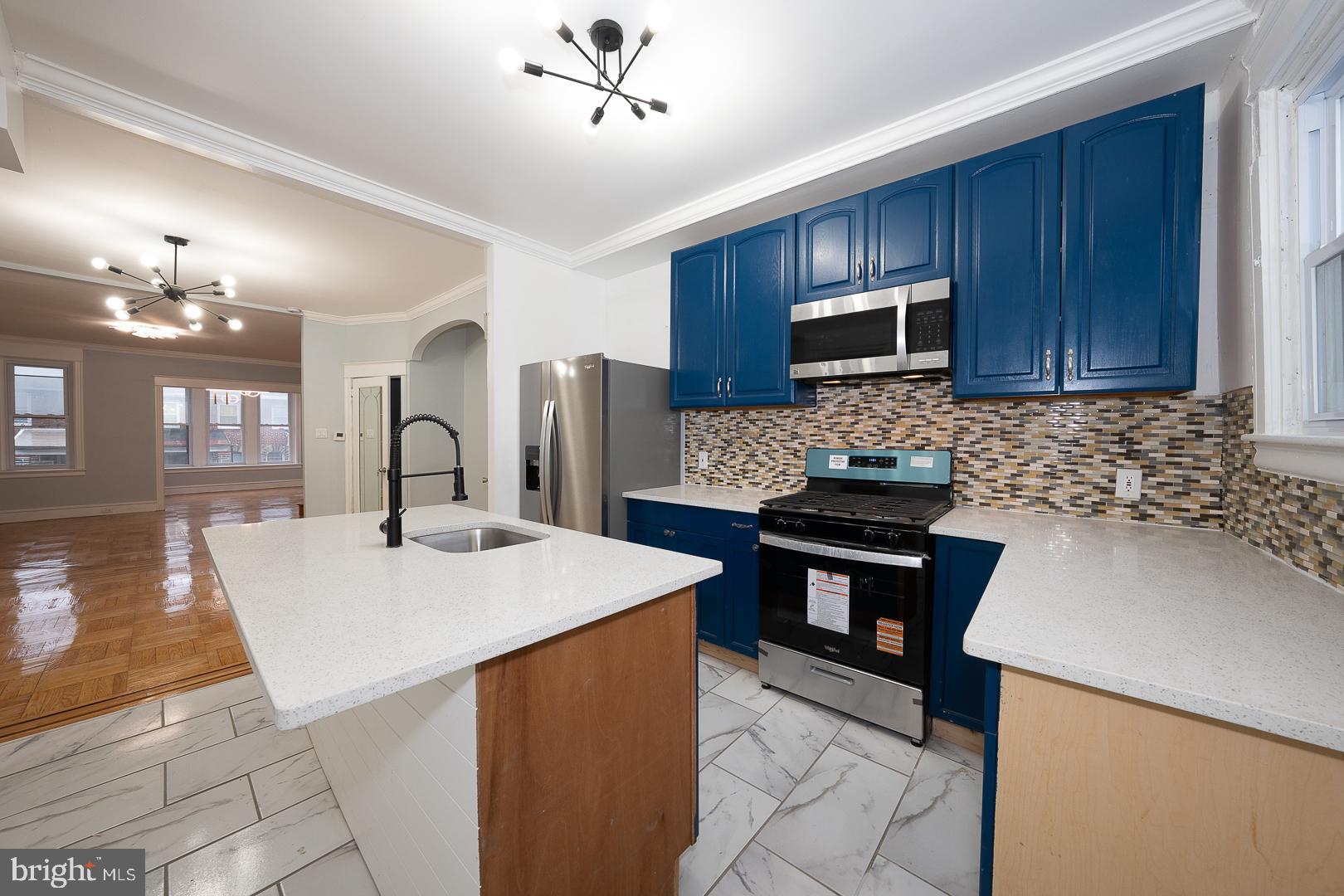 212 Copley Road Upper Darby, PA 19082 - Photo 18 of 69 a kitchen with stainless steel appliances kitchen island granite countertop a refrigerator a sink dishwasher a stove with wooden cabinets and floor
