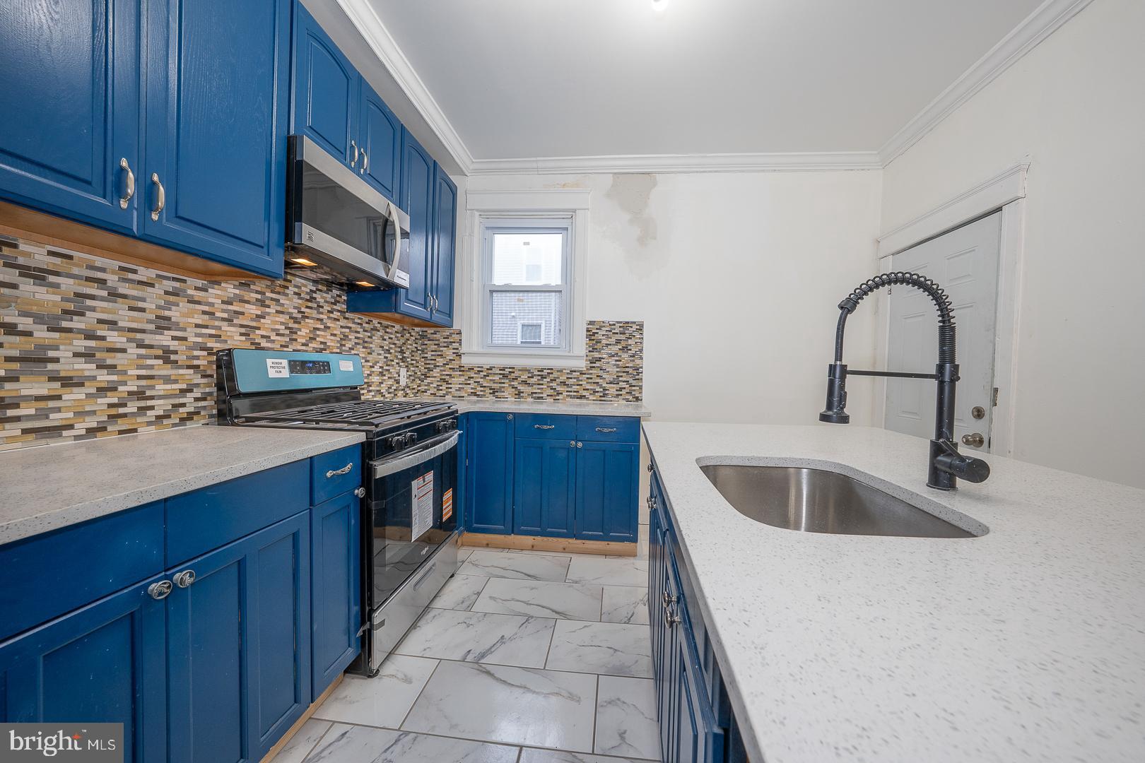 212 Copley Road Upper Darby, PA 19082 - Photo 22 of 69 a kitchen with stainless steel appliances granite countertop a sink stove and cabinets