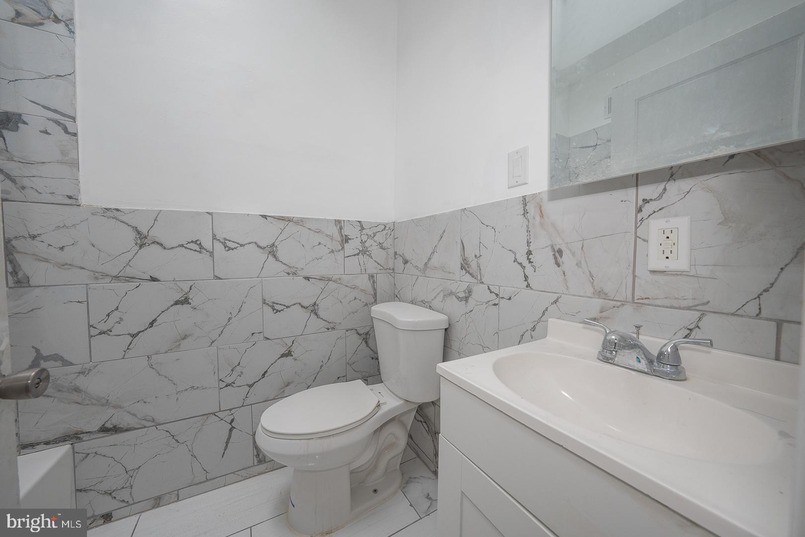 212 Copley Road Upper Darby, PA 19082 - Photo 36 of 69 a bathroom with a sink a toilet and a mirror